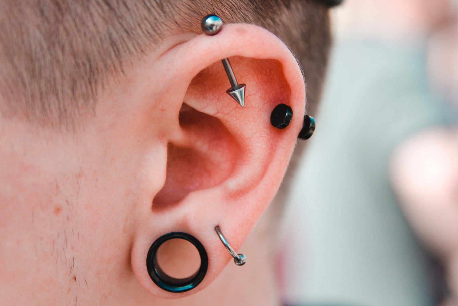 Hombre con muchos piercings en la oreja