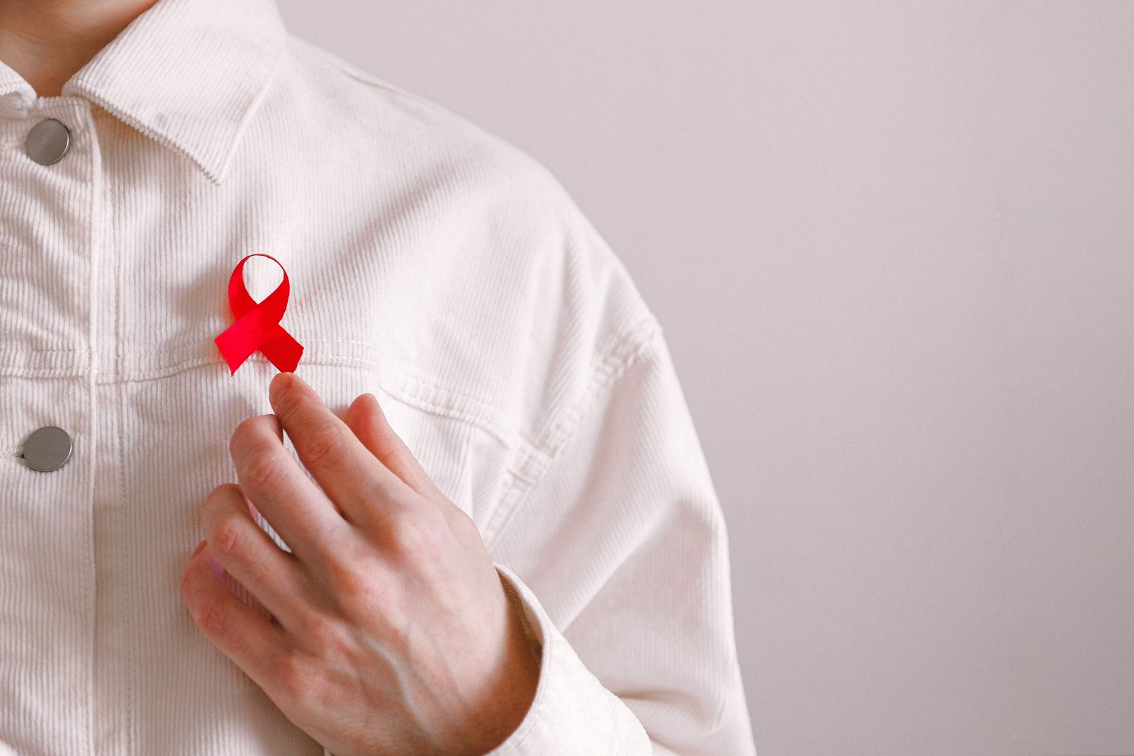 Hombre con un lazo rojo en la camisa en el Día Mundial de la Lucha contra el SIDA